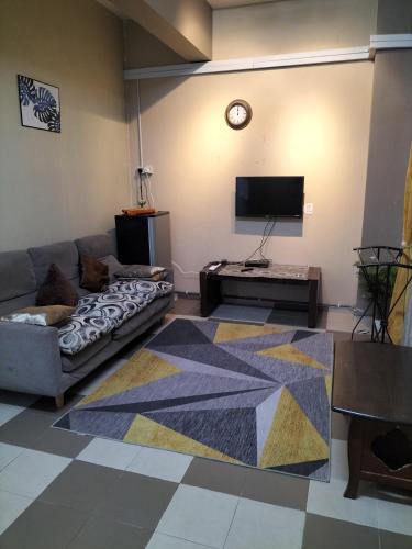 a living room with a couch and a tv at Ulfah Mersing الفة in Mersing