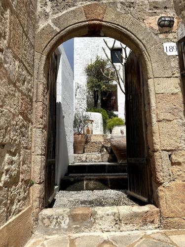 an archway in a stone building with stairs at Villa Kali in Líndos
