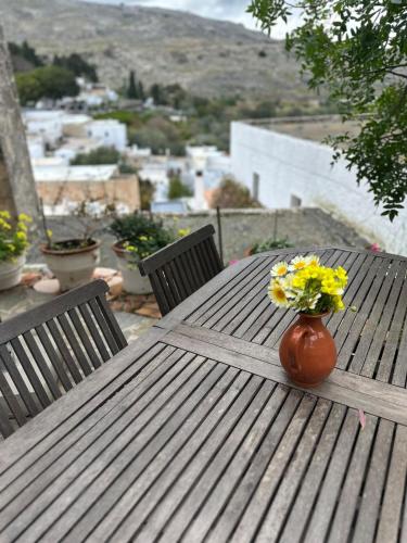 a vase of flowers sitting on a wooden table at Villa Kali in Líndos