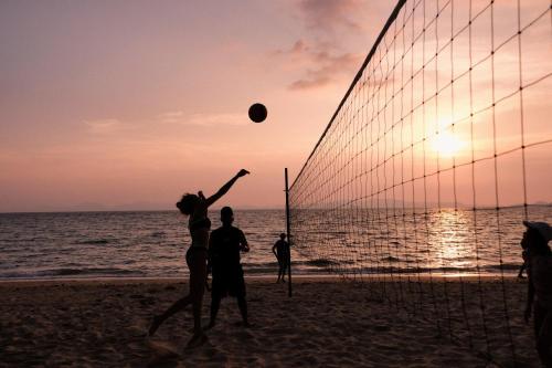 a group of people playing volleyball on the beach at VARANA Krabi Hotel in Klong Muang Beach