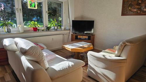 a living room with two chairs and a tv at Apartment Ferienwohnung Mali Duisburg Süd voll möbliert Urig near Autobahn Ubahn in Duisburg