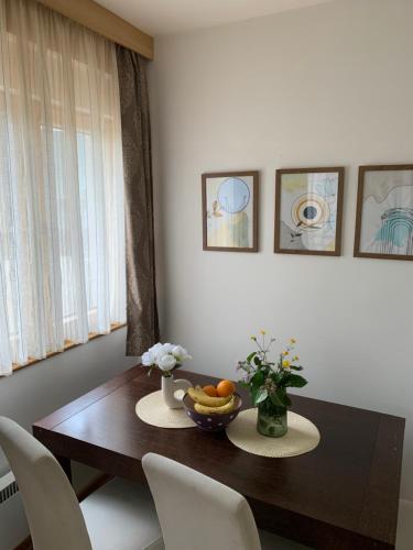 a dining room table with a bowl of fruit on it at Beli Apartman u Zlatiborskim konacima Bele vode bb in Zlatibor