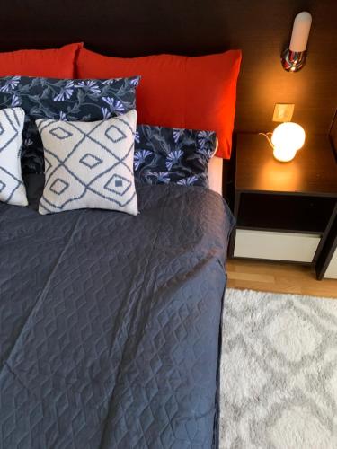 a bed with pillows on it in a bedroom at Beli Apartman u Zlatiborskim konacima Bele vode bb in Zlatibor