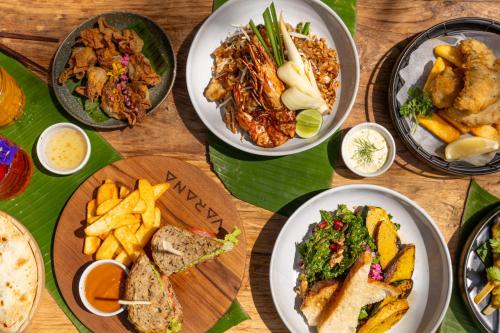 a wooden table with plates of food on it at VARANA Krabi Hotel in Klong Muang Beach