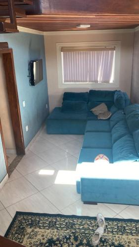 a blue couch in a living room with a window at Casa em Aparecida in Aparecida