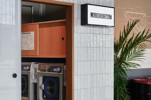 a door to a laundry room with a washer and dryer at Comfort Hotel Arlanda Airport Terminal in Arlanda