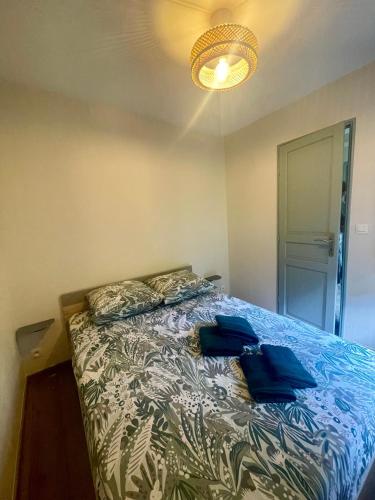 a bedroom with a bed with blue pillows on it at Petit appartement très cosy in Magland