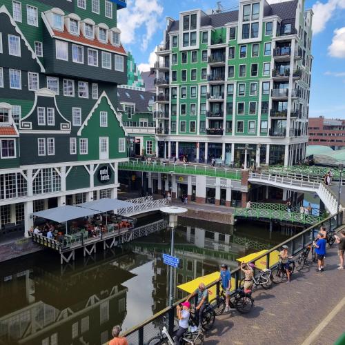 a group of people standing near a river with buildings at Hermitage Suites & Apartments - Amsterdam Zaandam in Zaandam