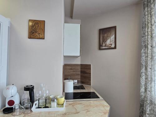 a kitchen with a counter with bottles and glasses on it at MA DONNA rooms in Floreşti