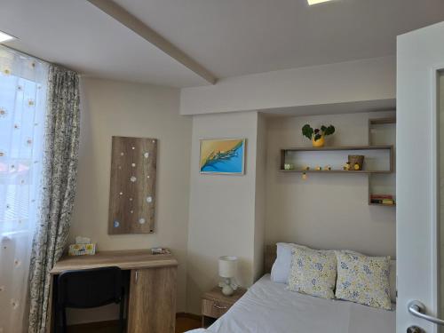 a bedroom with a bed and a desk and a window at MA DONNA rooms in Floreşti
