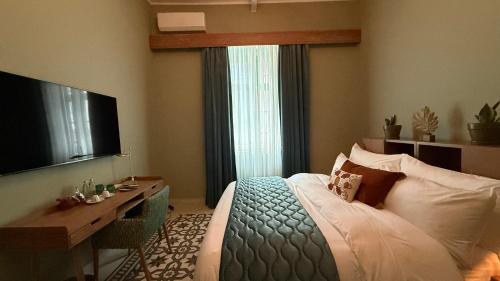 a bedroom with a bed and a desk and a television at Hotel Lost Ashrafieh in Beirut