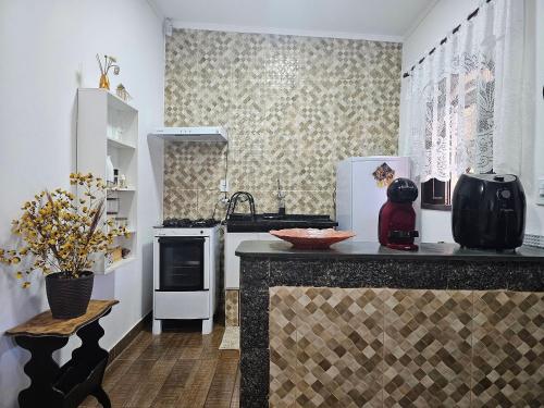 a kitchen with white appliances and a counter at Acesso à Praia Ar Condicionado Conforto Garantido! in Saquarema