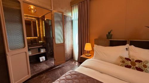 a bedroom with a bed and a lamp and a window at Hotel Lost Ashrafieh in Beirut