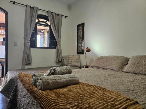 a bedroom with a bed with a brown blanket at Acesso à Praia Ar Condicionado Conforto Garantido! in Saquarema