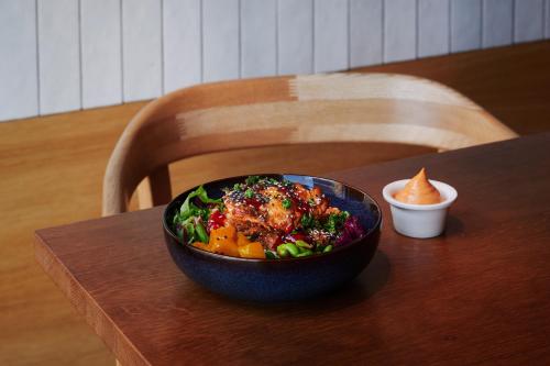 a bowl of salad sitting on a wooden table at Comfort Hotel Arlanda Airport Terminal in Arlanda