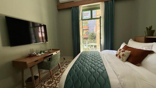 a bedroom with a bed and a desk and a television at Hotel Lost Ashrafieh in Beirut