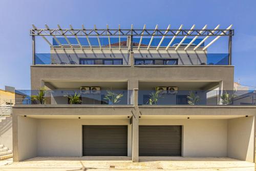 an apartment building with a glass facade at Villa Bella with Jacuzzi in Gouves