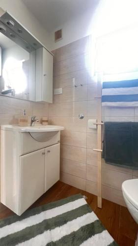 a bathroom with a sink and a toilet and a mirror at Mint Bellavista in Vir