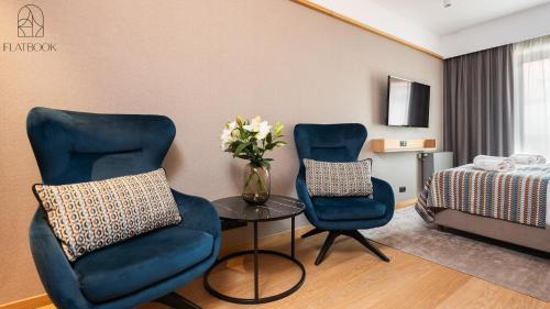 a hotel room with two chairs and a table and a bed at Flatbook - City Center SPA Apartments Deo Plaza Studio in Gdańsk