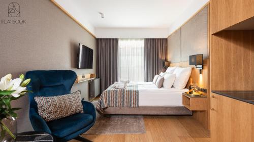 a hotel room with a bed and a chair at Flatbook - City Center SPA Apartments Deo Plaza Studio in Gdańsk
