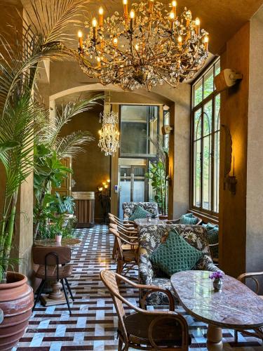 a living room with a chandelier and tables and chairs at Hotel Lost Ashrafieh in Beirut