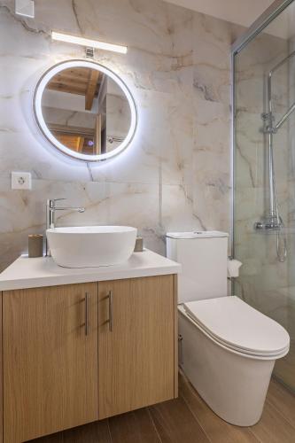 a bathroom with a sink and a toilet and a mirror at Villa Bella with Jacuzzi in Gouves
