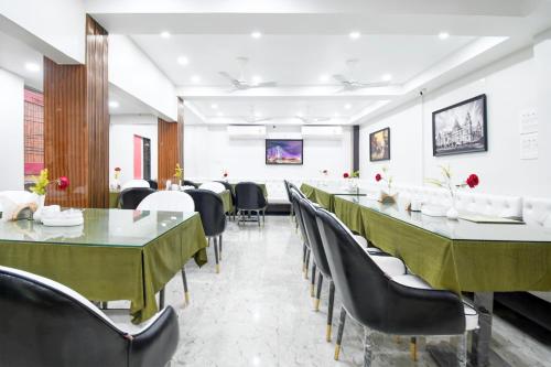 a dining room with green tables and chairs at Hotel Continental Restuarant & Cafe in Kolkata
