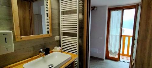 a bathroom with a white sink and a window at CA' DEL PITUR Apartments B&B Cicogna in Cicogna
