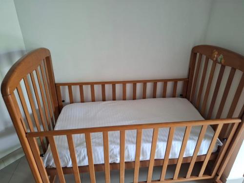 a wooden crib with a white mattress in a room at Kandy Grand Hill in Kandy
