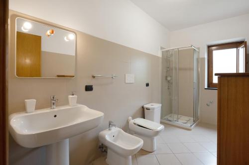 a white bathroom with a sink and a toilet at Zio Gennaro Residence in Agerola