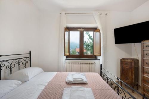 a bedroom with a bed and a flat screen tv at Zio Gennaro Residence in Agerola
