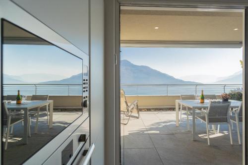 a balcony with tables and chairs and a view of the ocean at Valarin Luxury Apartments & Wellness, Vercana by Rent All Como in Vercana