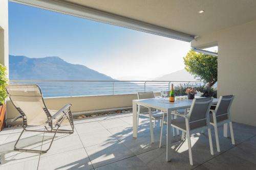 a balcony with a table and chairs and a view of the ocean at Valarin Luxury Apartments & Wellness, Vercana by Rent All Como in Vercana