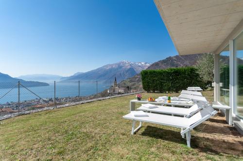 a row of white lounge chairs sitting on top of a field at Valarin Luxury Apartments & Wellness, Vercana by Rent All Como in Vercana