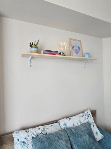 a white wall with a shelf above a bed at MA DONNA rooms in Floreşti