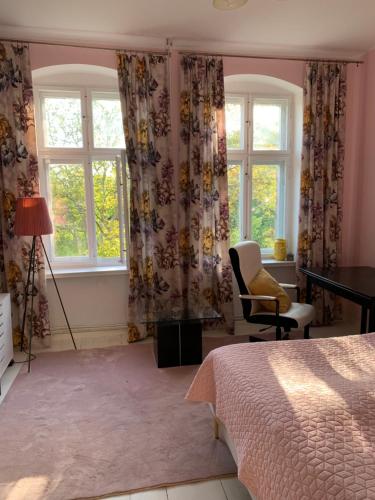a bedroom with a bed and a desk and windows at Villa Maria Rosaria in Oborniki Śląskie