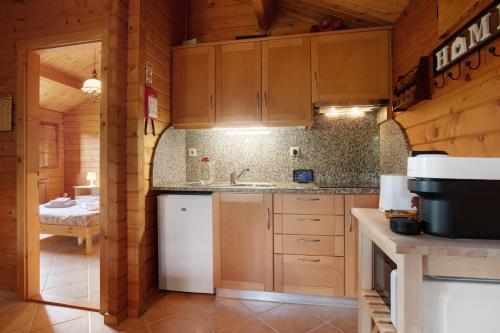 a kitchen with wooden cabinets and a sink in a cabin at Quinta Do Castelo - Casa de Madeira in Reguengo Grande