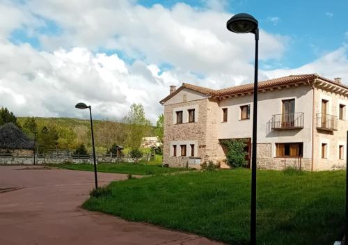 ein Gebäude mit zwei Straßenbeleuchtung davor in der Unterkunft Apartamento Rural Dehesa de Solanillos in Mazarete