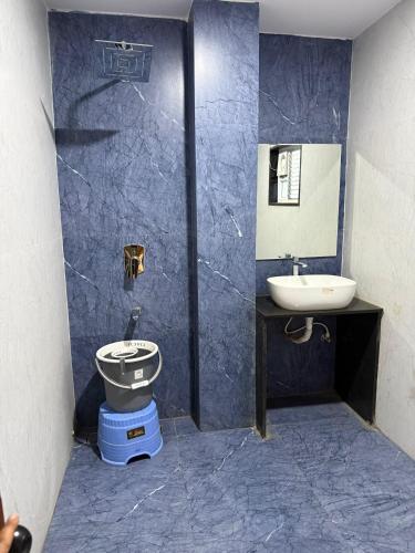 a blue bathroom with a toilet and a sink at Agarwal's Residency in Visakhapatnam