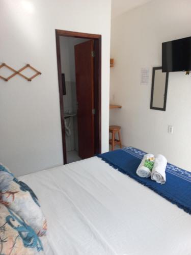 a bedroom with a bed with two towels on it at Hospedaria da Praia Fortaleza in Fortaleza