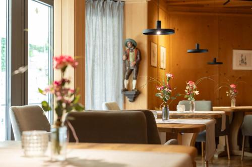 a restaurant with tables and a statue on the wall at Hotel Burggräflerhof in Merano