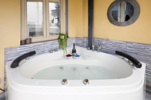 una grande vasca bianca in un bagno con finestra di Nadia's Lovely Home - WITH PRIVATE GARDEN AND JACUZZI a Firenze