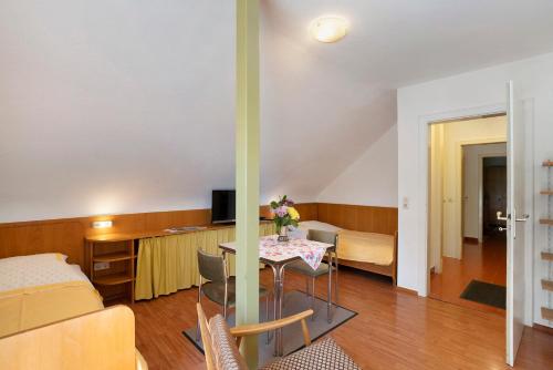 a living room with a table and a bedroom at Gästehaus Hirzel in Bad Wildbad