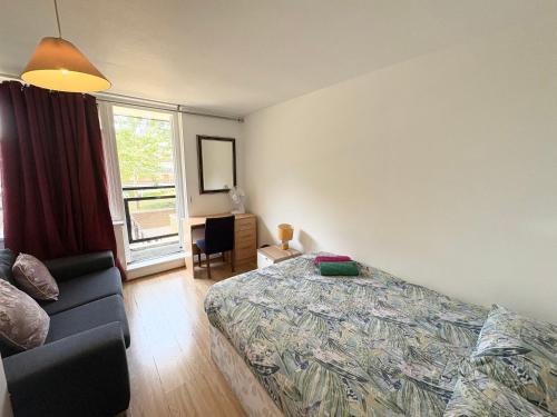 ロンドンにあるPerfect Stay Close to Centre Londonのベッドとソファと窓のある寝室