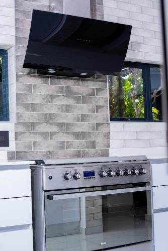 a stove top oven with a microwave above it at Zenz BnB in Empangeni