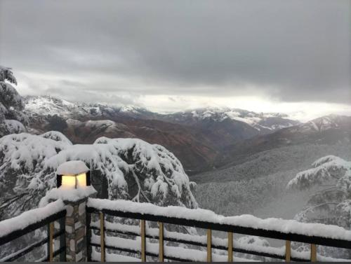 a light on a fence with snow covered mountains at RATAN HOMES Sunrise Valley in Jāmb