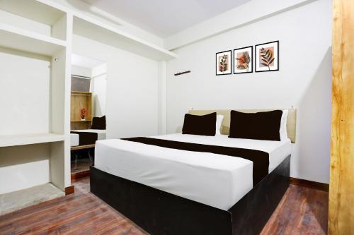 Hotel O George Town في Colonelganj: غرفة نوم بها سرير كبير في الغرفة