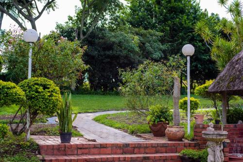 a garden with a brick path with plants and a street light at Zenz BnB in Empangeni