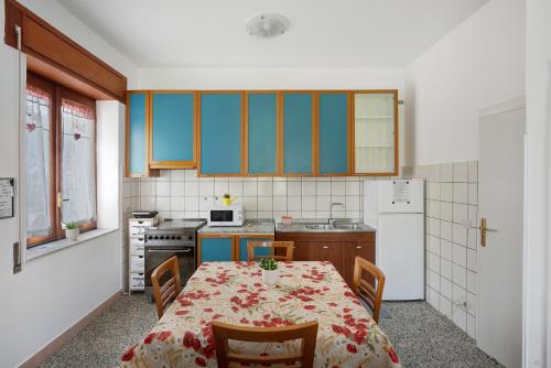 a kitchen with a table and chairs and a kitchen with blue cabinets at Zio Gennaro Residence in Agerola