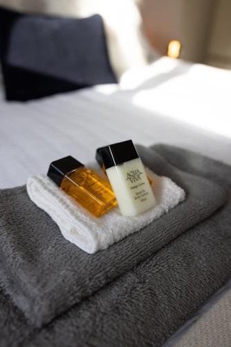 a pile of towels and a candle on a bed at 1BR w Sofa Bed Private Yard in Exmouth